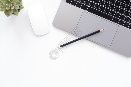 书桌上的笔与笔记本电脑背景图片