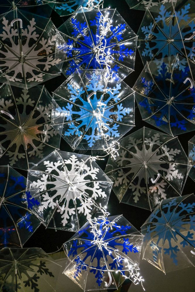 白雨伞的美丽由圣诞光照亮装饰着秋千的街道图片