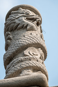 龚在青岛附近的罗山龙古老雕像背景
