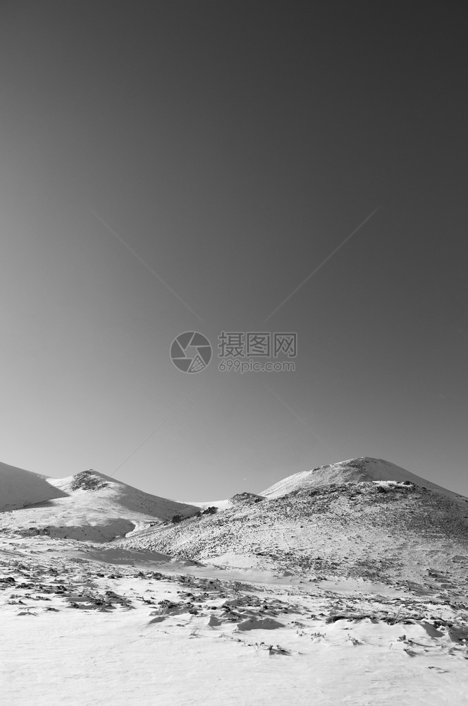 冬季在晴天的上满是雪的火山黑色和白的图像图片