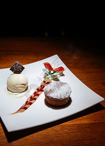 法国甜点巧克力味熔岩蛋糕香草冰淇淋奶油酱和鲜草莓图片