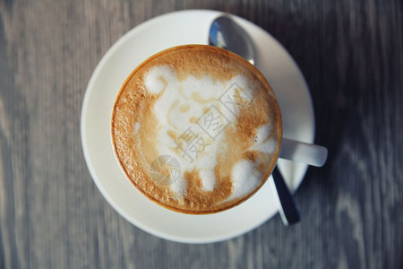 带喜洋洋拉花图案的咖啡俯视图背景图片