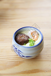 陶瓷碗里的蒸鸡蛋加蘑菇和虾仁背景图片