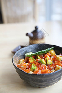 黑瓷碗里的蔬果加鱼子酱和生鱼块图片