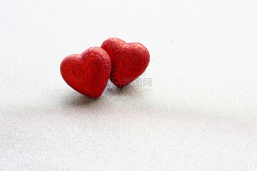 红心在银色闪光纸背景上的形状在情人节的爱概念中复制空间图片