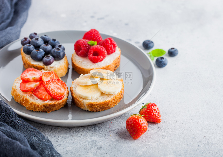 面包片和各种莓果在灰色碟子上图片