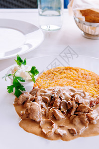 奶油蘑菇肉汁酱和炸的罗索薯当地菜白盘高清图片