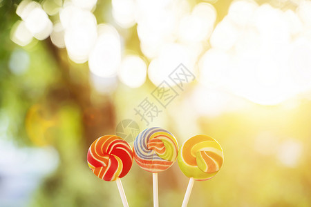 在日落时用阳光透过彩虹棒糖是小孩童年和幸福的概念图片