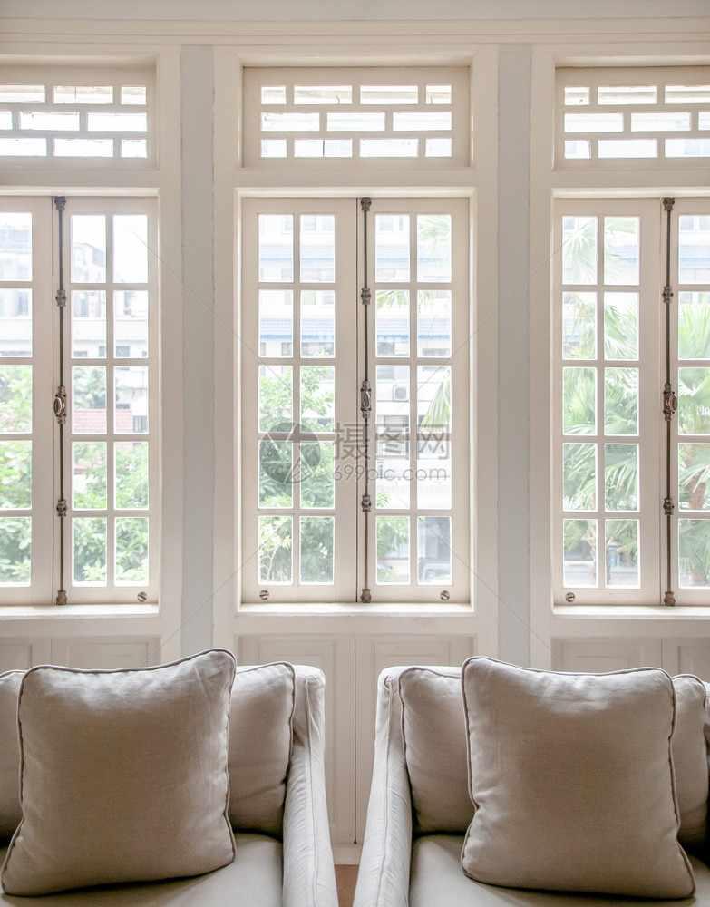 白色殖民古老的客厅有扶椅和典型最起码设计枕头窗户有自然光的舒适房间图片