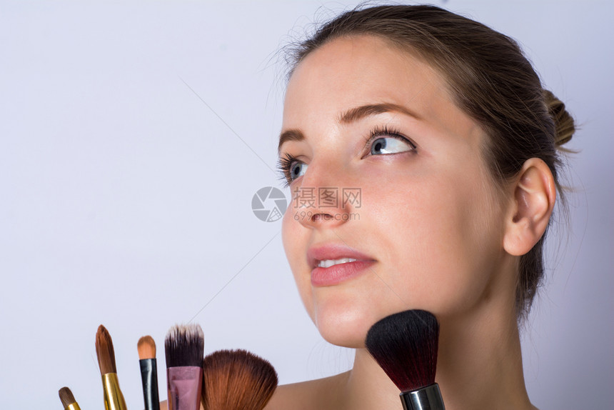 摄影棚上拿着化妆刷的年轻女子图片