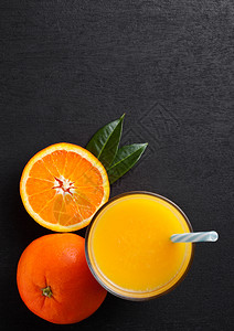 黑色木制背景的生橙子图片