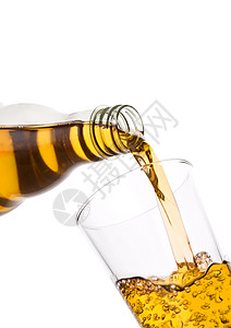 将新鲜苹果汁从瓶子倒在白底的玻璃杯上图片