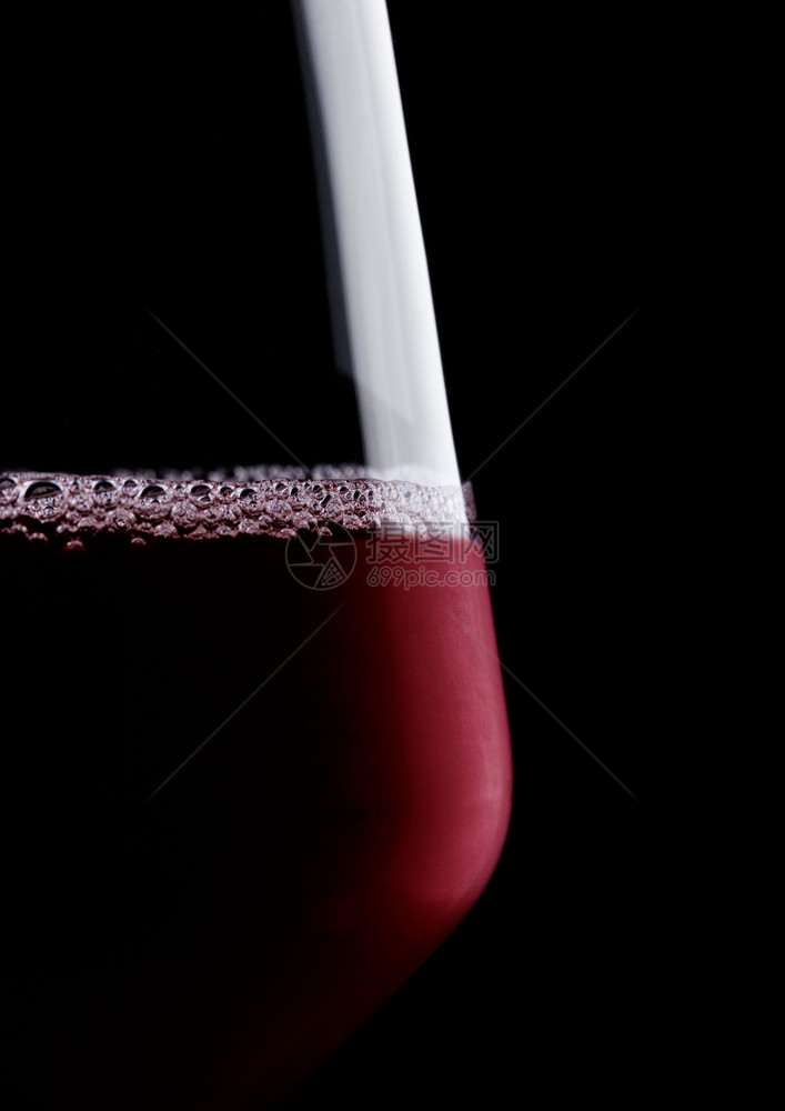 玻璃红葡萄酒宏有泡和黑色背景反射图片