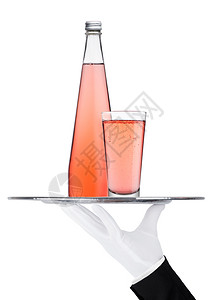 装有粉红色柠檬水汽饮料瓶和白底玻璃的托盘图片
