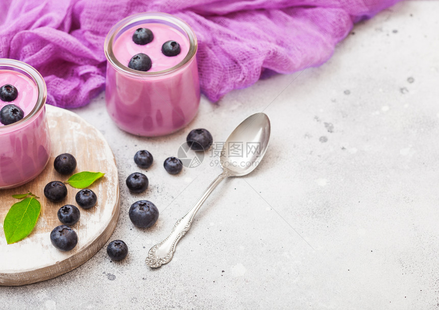 鲜自制奶油蓝莓酸在旧木板上鲜蓝莓在石桌背景上银勺子图片