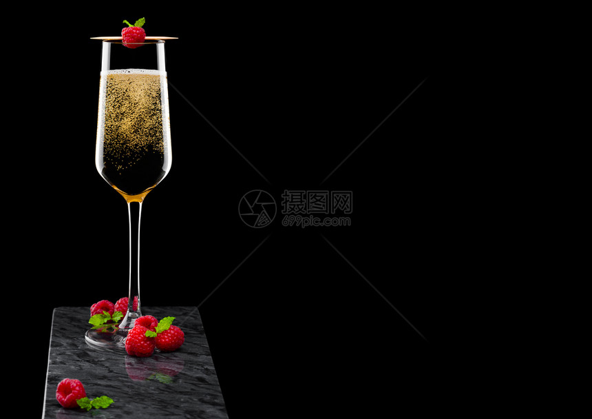 优雅的黄色香槟杯子上面有香草和鲜莓还有薄荷叶在黑大理石板上粘黑大理石板图片