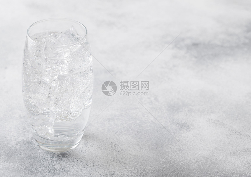 一杯闪亮的柠檬水饮料冰块和泡沫在石器厨房背景图片
