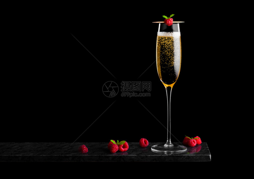 优雅的黄色香槟杯子上面有草莓和鲜还有薄荷叶在黑大理石板上粘黑大理石板图片