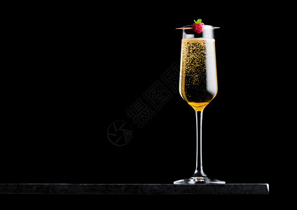 优雅的黄色香槟杯子黑大理石板上黑色背景的红莓图片