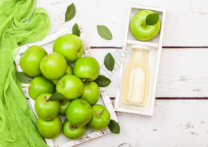 玻璃瓶新鲜有机苹果汁在木本底盒装绿苹果图片
