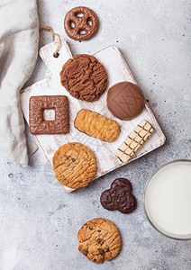 燕麦和巧克力饼干选择木板上有一杯牛奶石头厨房背景图片