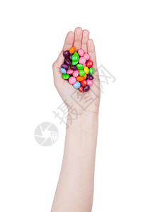 女手握着白色背景的圆玻璃巧克力糖果图片