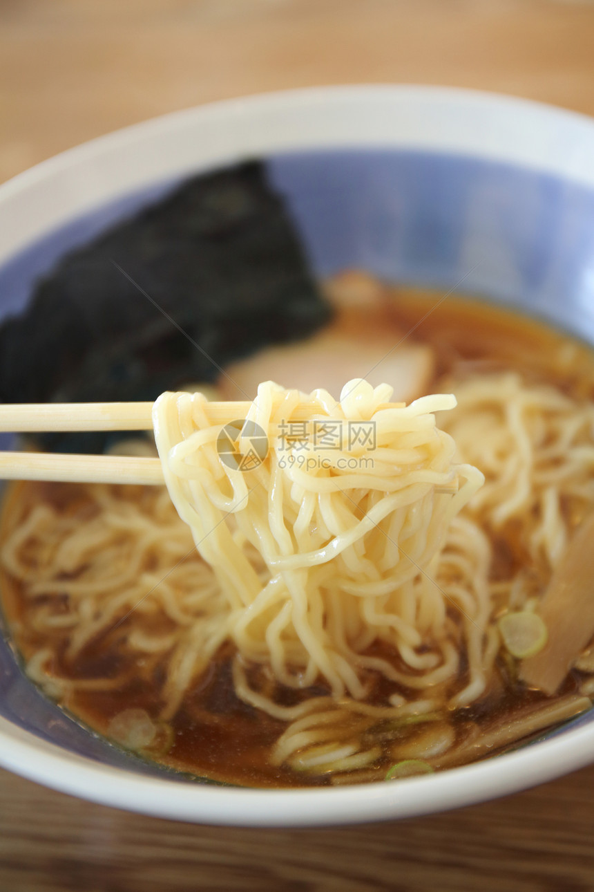 夹起木桌上的日式清汤面图片