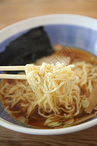 夹起木桌上的日式清汤面图片