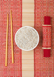 白碗加煮有机basmtiJsmne大米加木筷子和竹地垫上的甜豆酱大豆高清图片素材