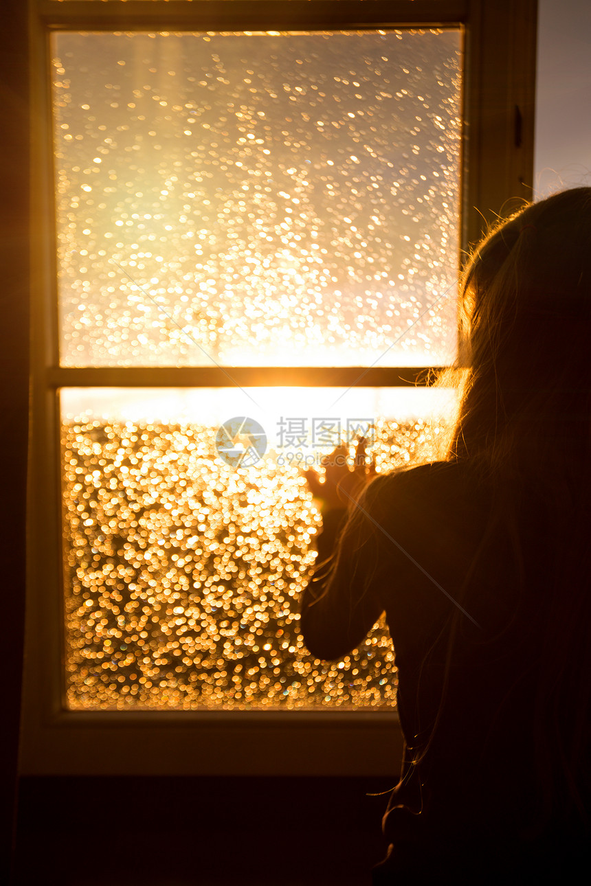 窗外美丽的日落光照亮窗外情绪女孩在下雨时向窗外看图片