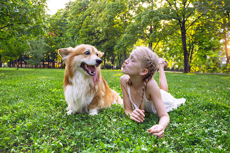 小狗和小女孩在草地上玩耍图片