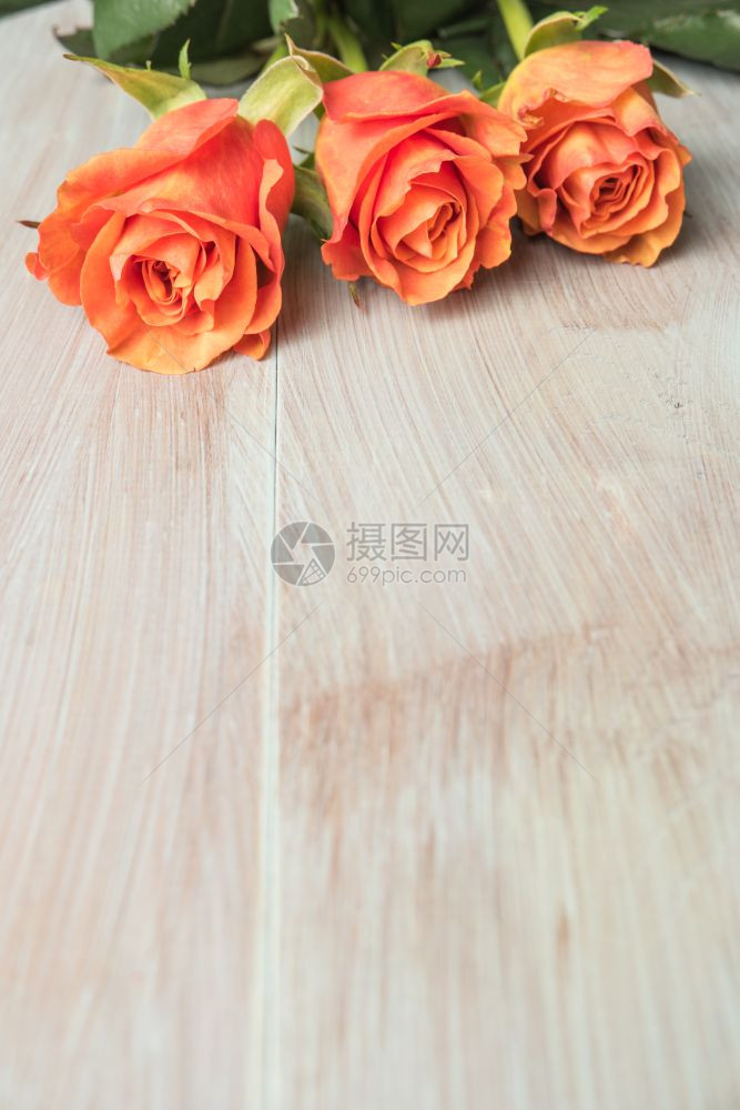 木制桌上一束橙色玫瑰复制空间图片