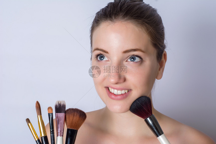手拿化妆刷的年轻女子图片
