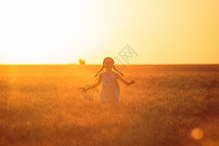 小女孩跑在橙色晚麦田图片素材
