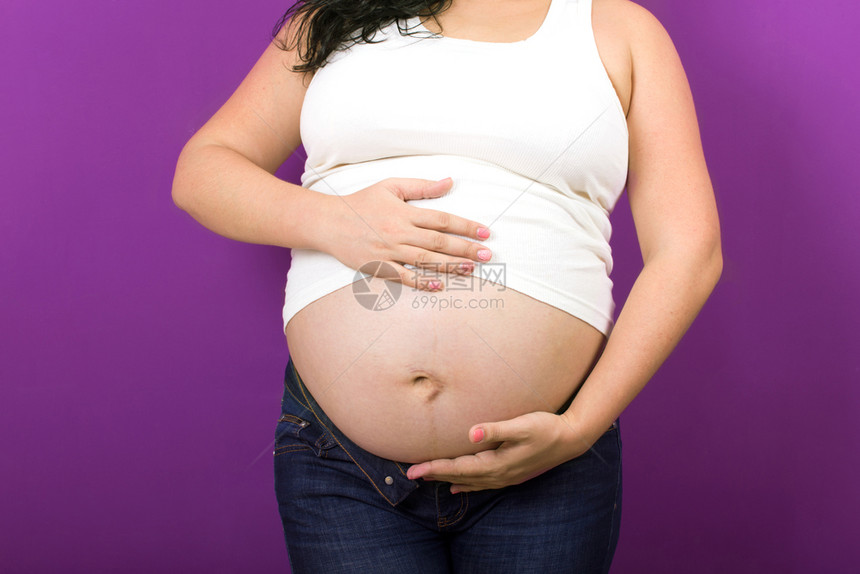 紫色背景上的美丽孕妇图片
