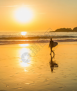 龟波气功素材冲浪者在沙滩上行驶到海洋的脚影景沙滩藻龟等的金色日落背景