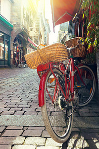 在著名城市迪南的美丽街道上骑着红色的旧式自行车高清图片