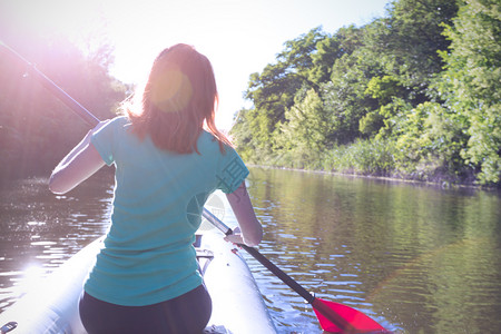 划船的女孩夏季和活跃的体育动日落时女孩皮艇背景