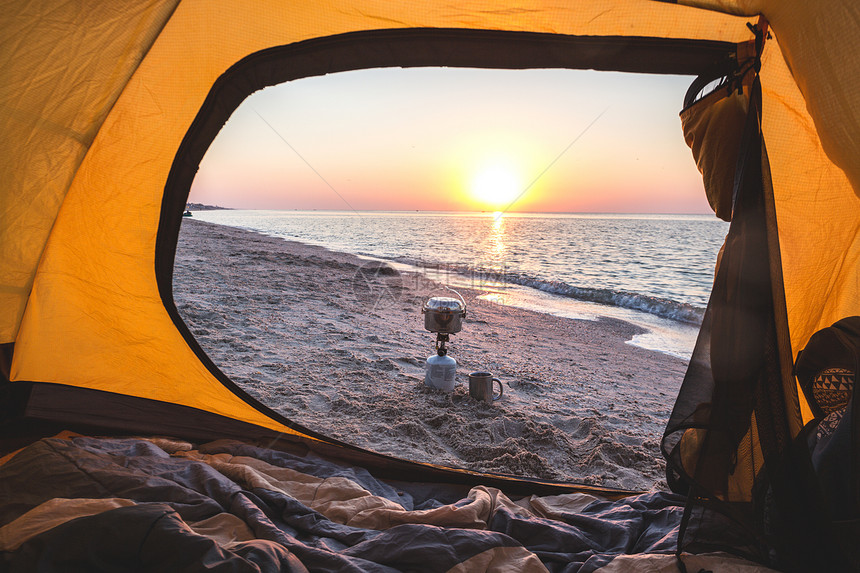 快乐之旅观看海燃烧器保龄球手杯子从黄色的帐篷在黎明海滩上图片