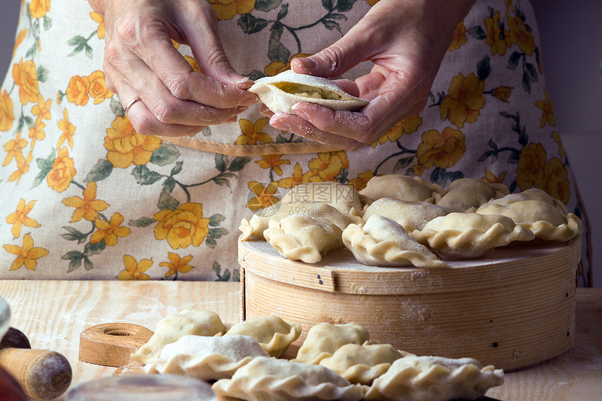 乌拉尼传统面包制品由女手制作小孔生锈风格反光照片图片