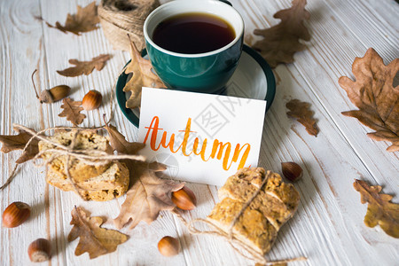 美丽的秋背景茶杯饼干秋叶和登记背景图片