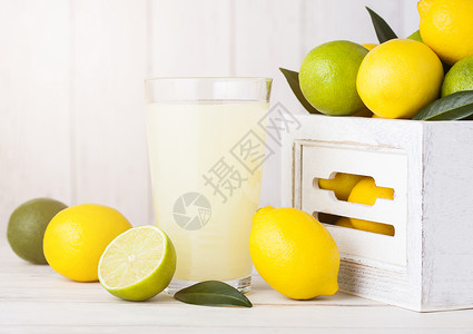 矢量柠檬饮料白木箱中含有生柠檬和石灰的有机新鲜柠檬和汁背景