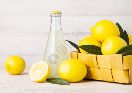 有机新鲜柠檬汁的玻璃瓶木本生竹篮中柠檬图片