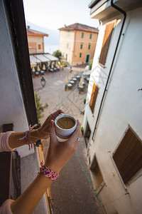 早上一个女孩手拿着咖啡在小镇的tremosintaly图片