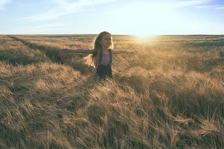 小女孩跑在橙色晚麦田生活方式高清图片素材