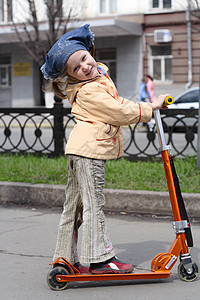 女孩在城市骑着滑板车图片