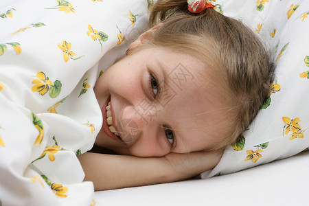 笑的小女孩躺在床上图片