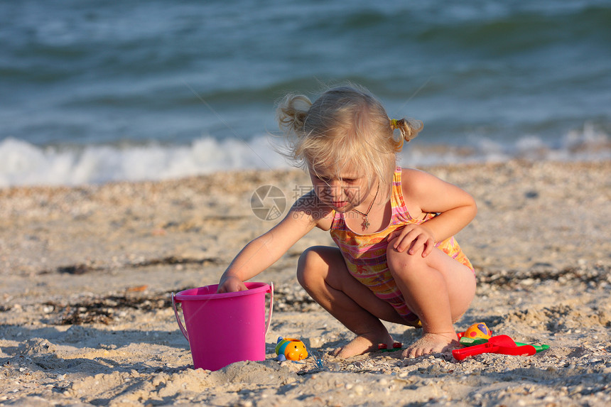 小女孩在海滩上带着玩具欢乐图片
