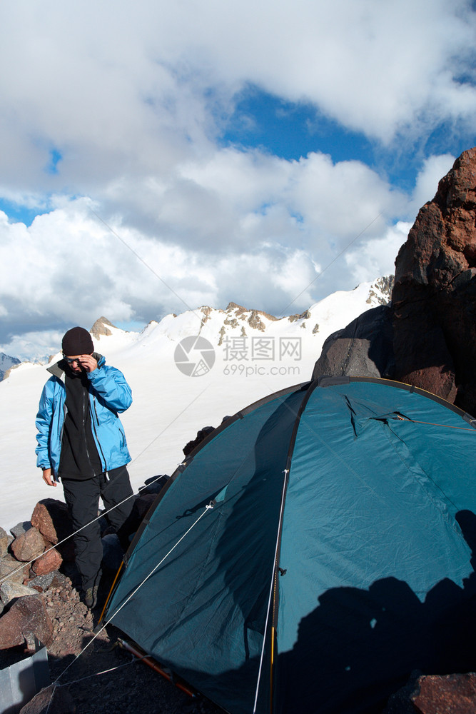 山地营帐篷附近休息的徒步旅行者图片