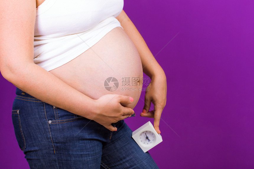 紫色背景上的美丽孕妇图片